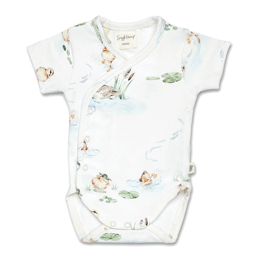 Baby onesie with nature-themed print on a white background