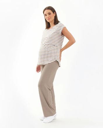Pregnant Woman wearing a striped sleeveless top and beige pants on a white background