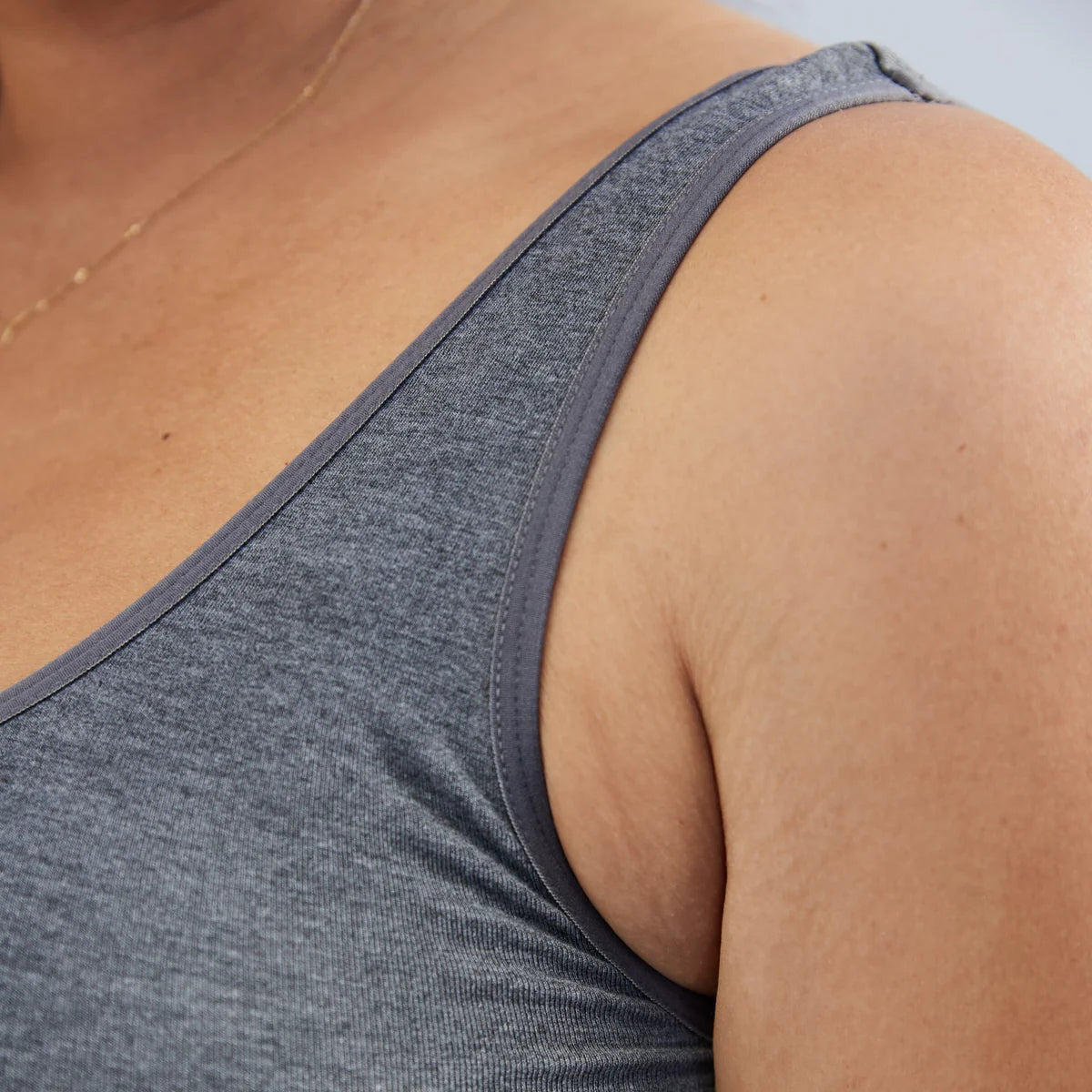 Grey tank top worn by a pregnant woman with a neutral background