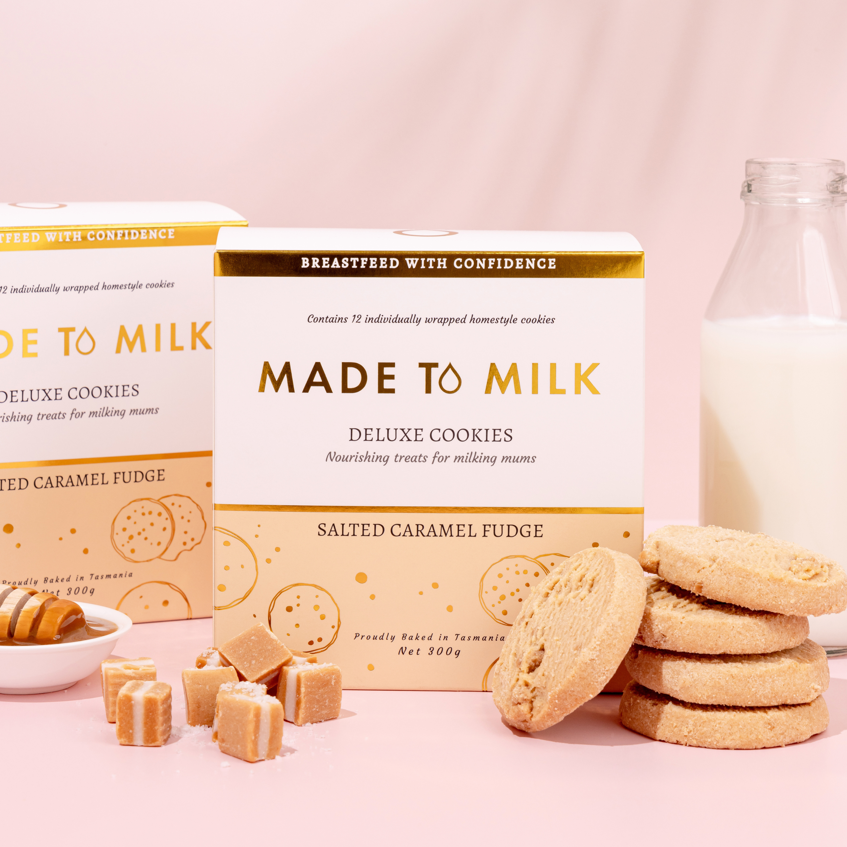 Boxes of 'Made to Milk' deluxe cookies with cookies and a bottle of milk on a pink background