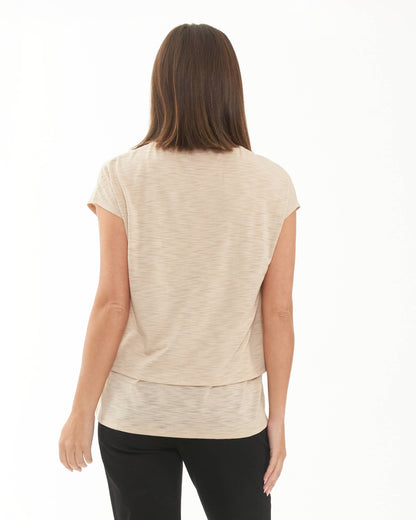 Pregnant Woman wearing a beige short-sleeve top on a white background