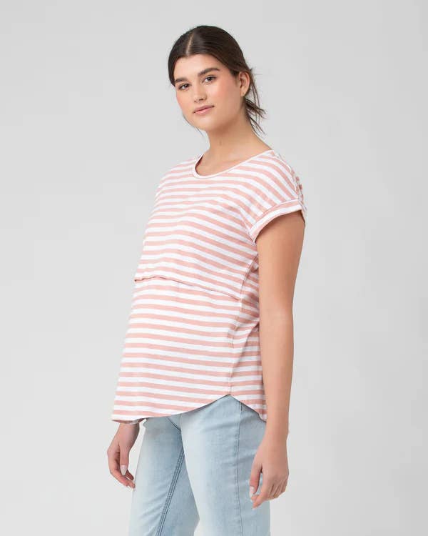 Pregnant Woman wearing a pink and white striped t-shirt against a plain background