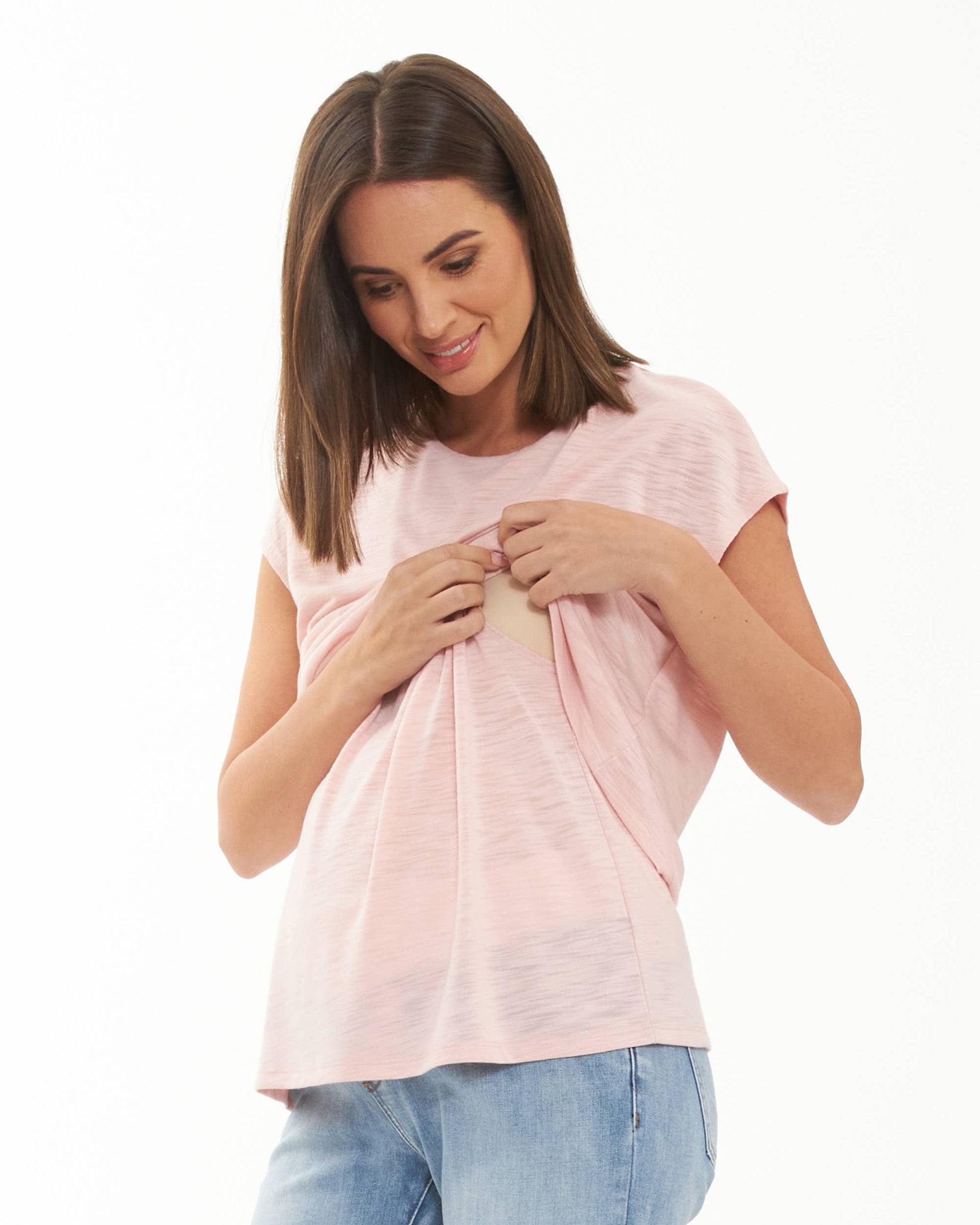 Pregnant Woman wearing a pink t-shirt and blue jeans on a white background