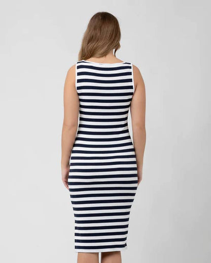 Pregnant Woman wearing a black and white striped dress on a plain background