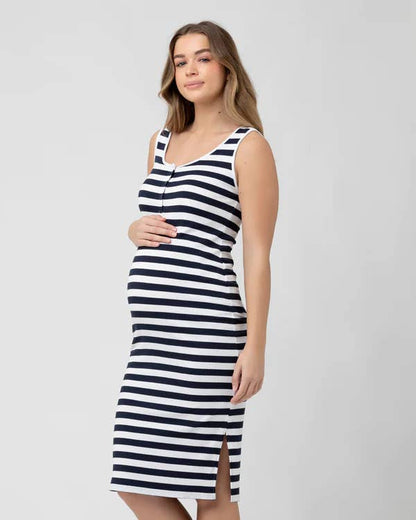 Pregnant Woman wearing a black and white striped dress on a plain background