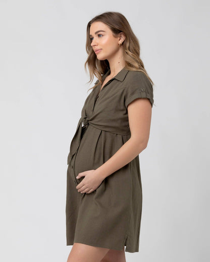 Pregnant Woman wearing a green dress against a white background