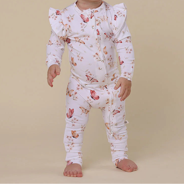 Baby wearing a floral outfit on a beige background