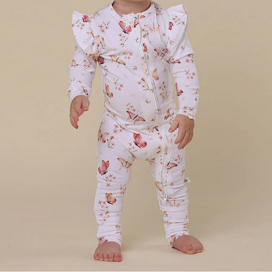 Baby wearing a floral outfit on a beige background