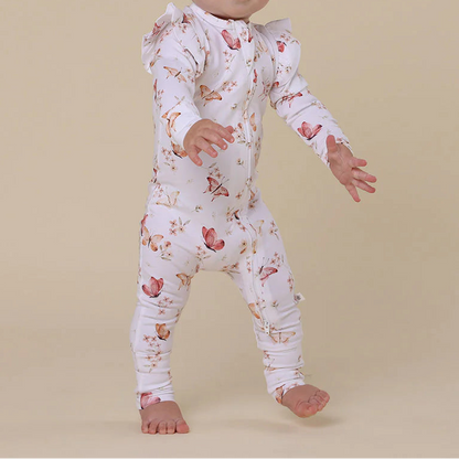 Baby wearing a floral onesie on a beige background
